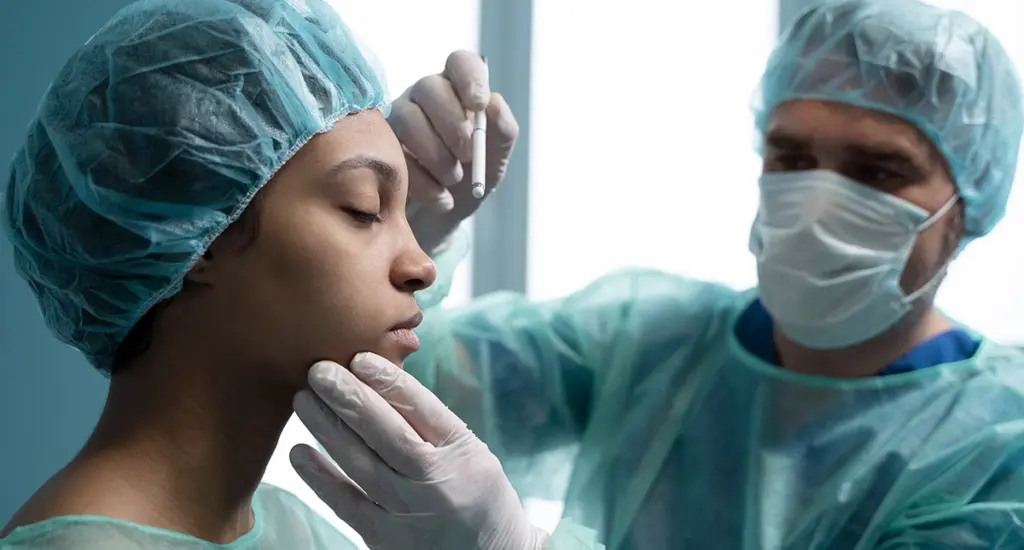 Cirurgião plástico analisando exames de rinoplastia em consultório